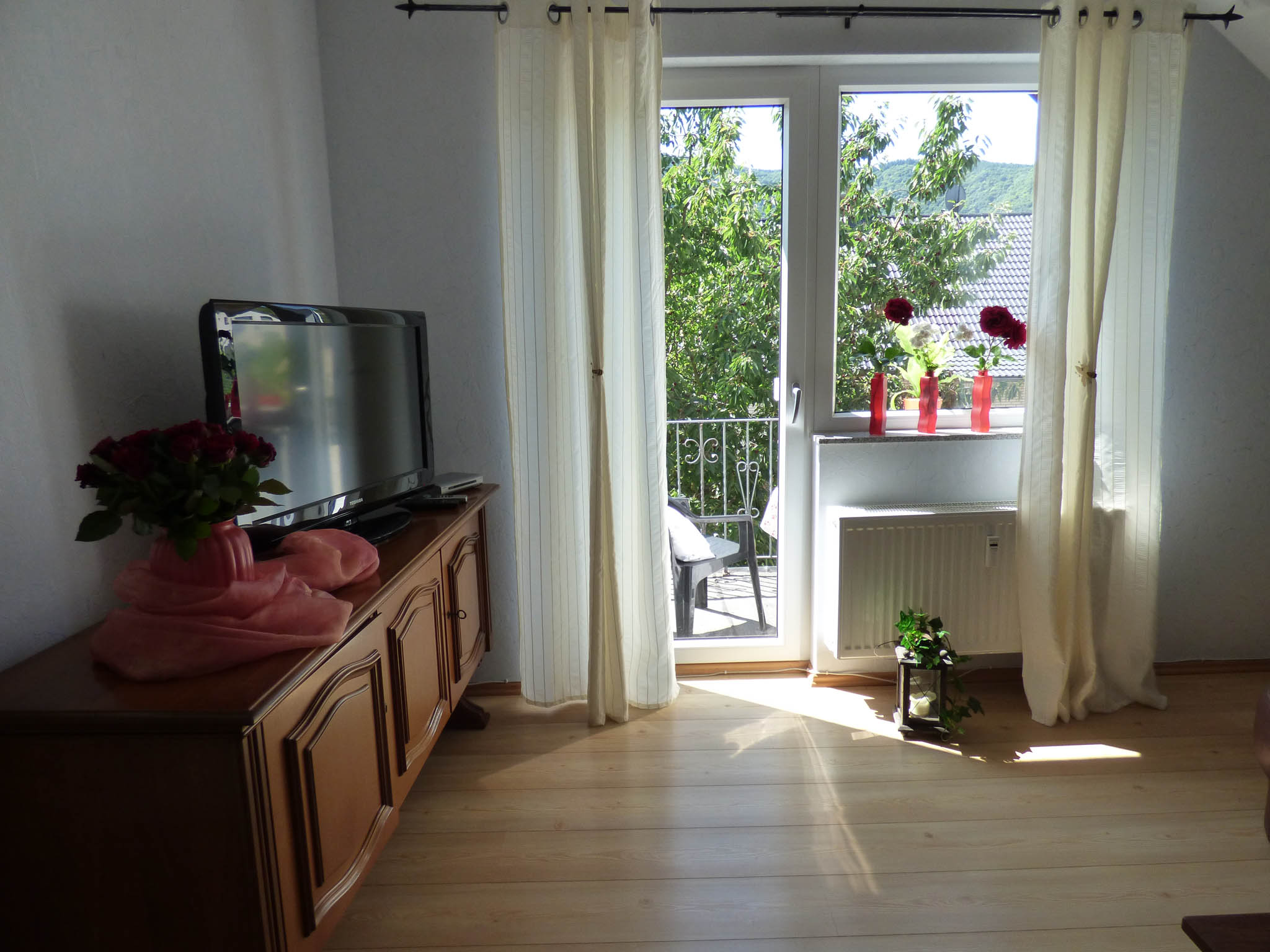 Relaxen in der Eifel Wohnzimmer mit Blick zum Fernseher und Ausgang zum Balkon 